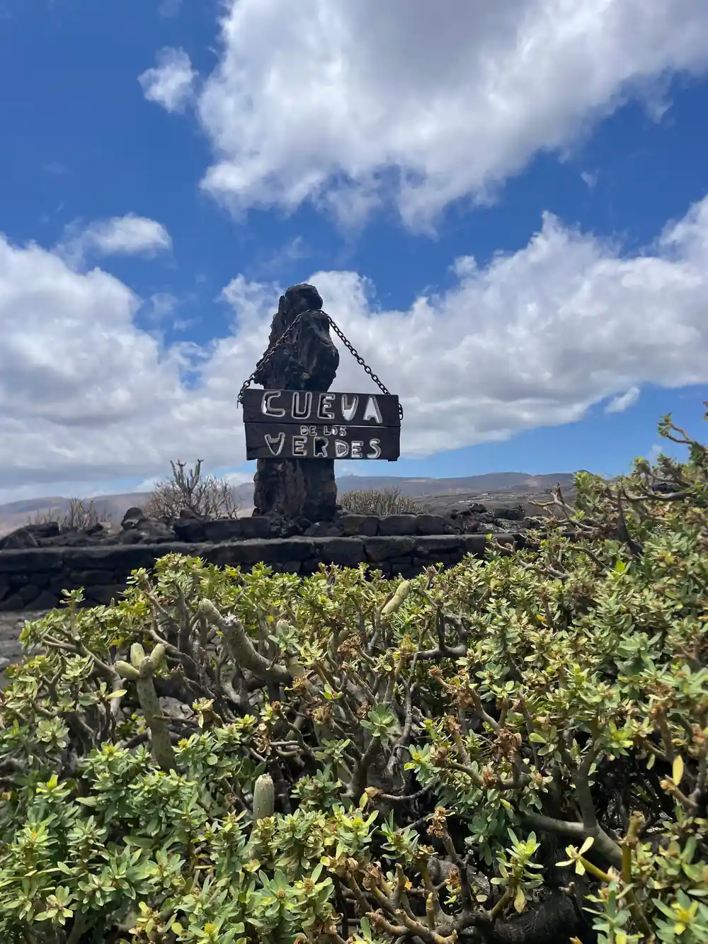 Black volcanic rock formation with sign landmark
