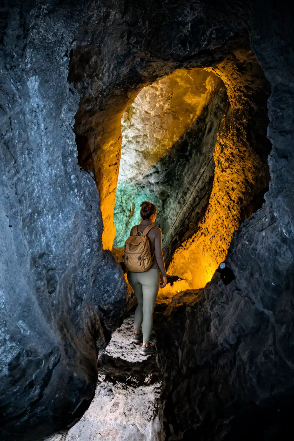 Bright turquoise mineral pool surrounded by dark volcanic rock formations