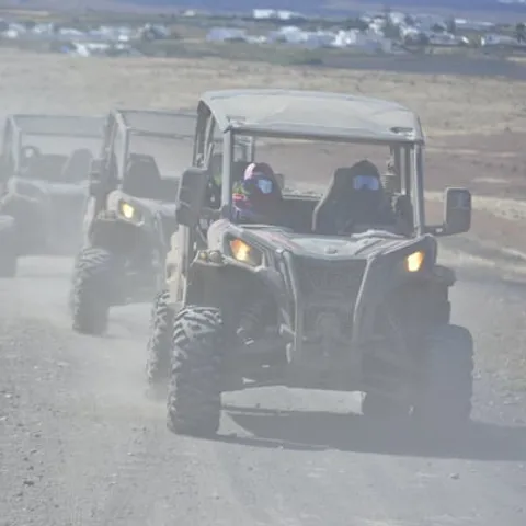 Convoy of off-road buggies raising dust