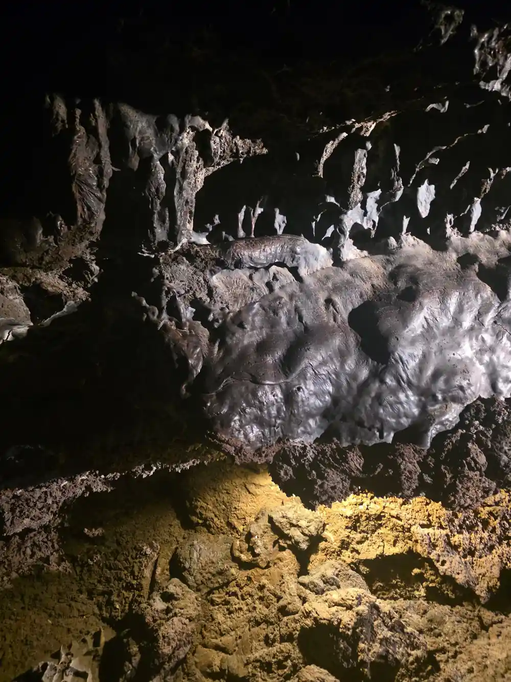 Cave interior with white mineral deposits and yellow lighting