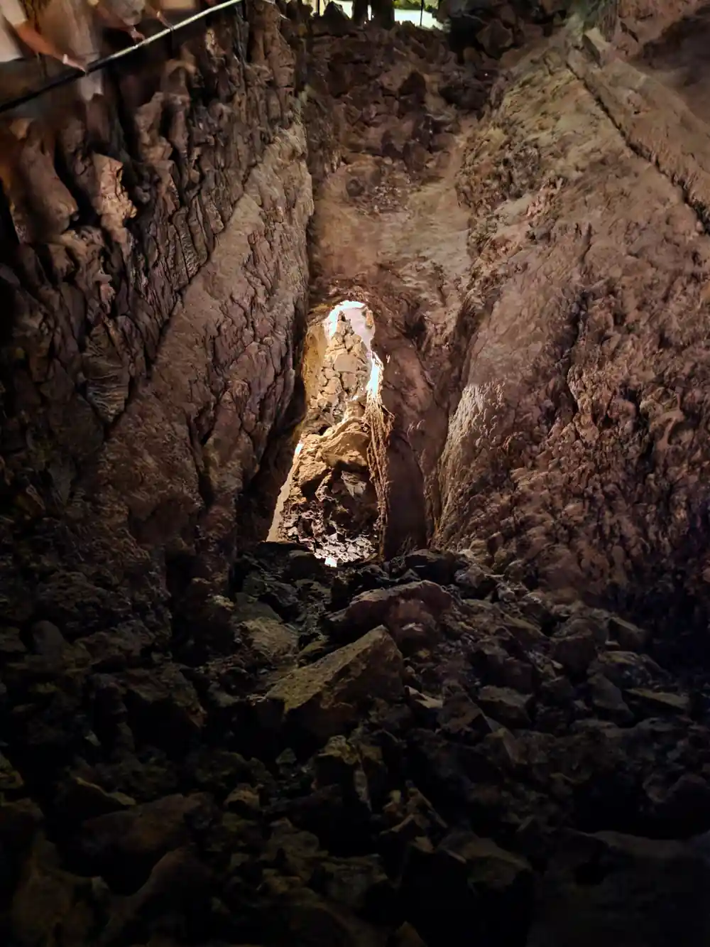 Dark lava rock tunnel with opening to light