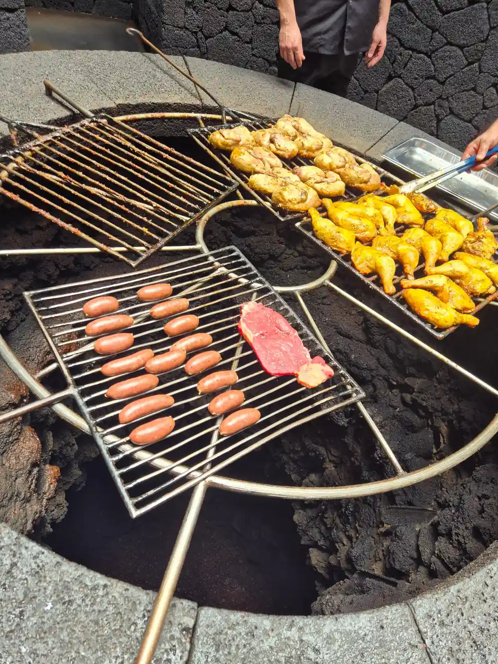 Food cooking on grill over volcanic heat source in ground