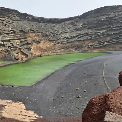Green lagoon below the eroded crater wall at El Golfo