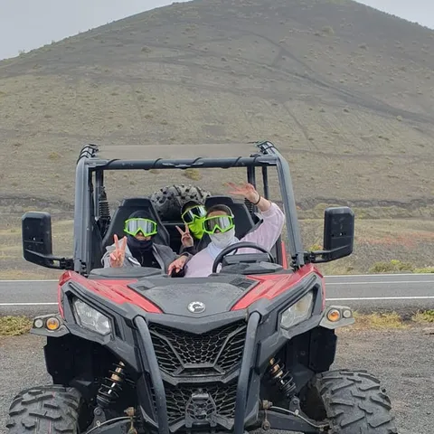 Red and black buggy parked beside a volcanic road