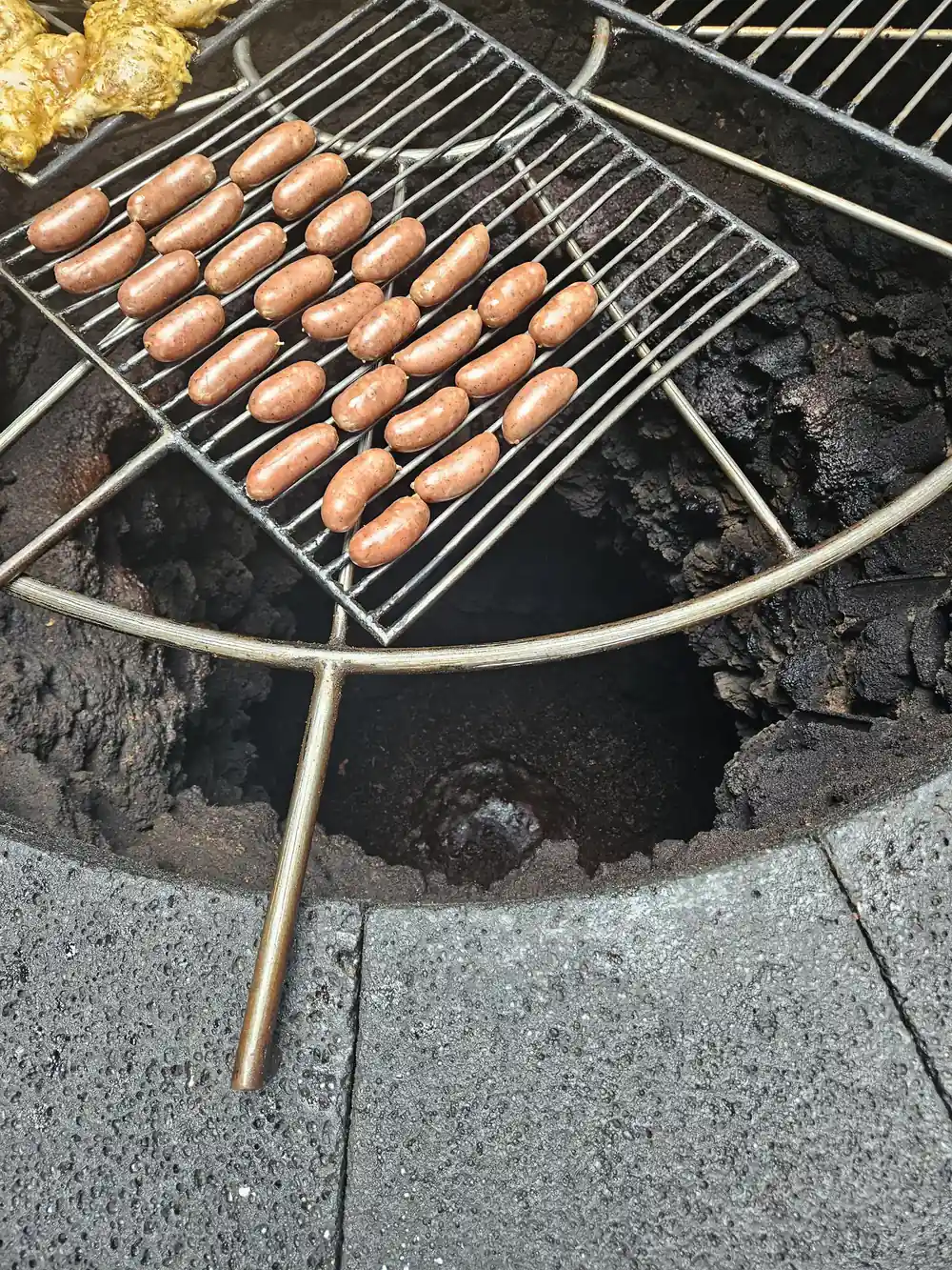 Sausages cooking on grill over geothermal heat in ground