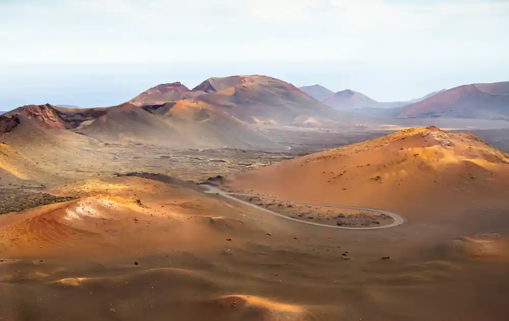 Volcanic cones and red sand dunes across desert landscape