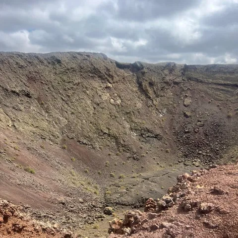 Wide volcanic crater with red and brown walls