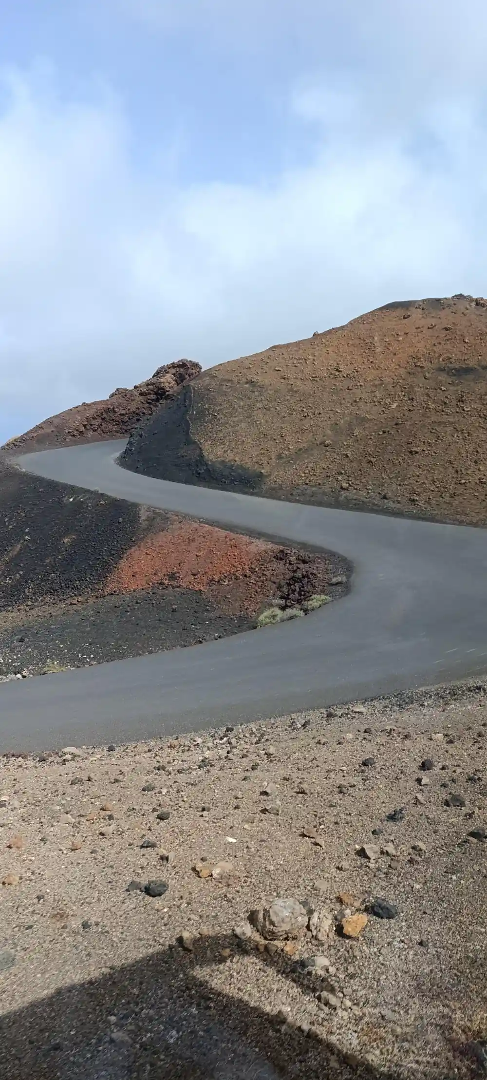 Volcanic landscape with dark crater rim and blue-green water