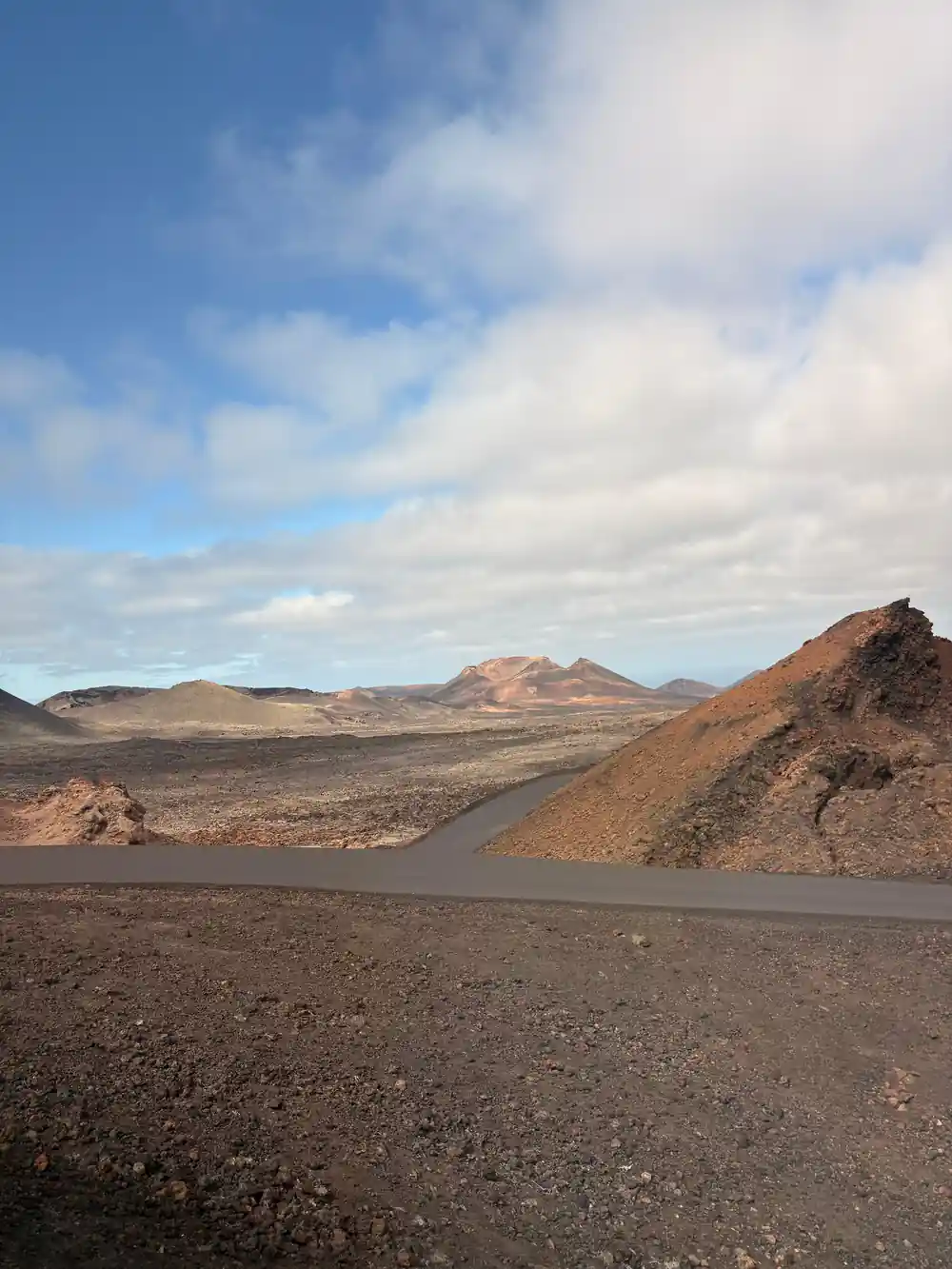 Volcanic landscape with dark lava fields and distant mountains